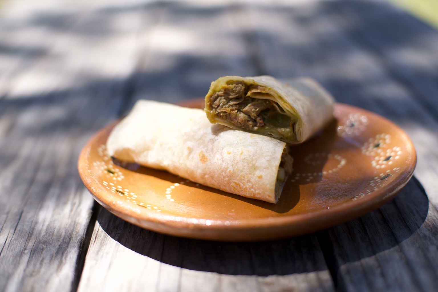Chihuahua burrito cut open to show shredded beef in chile verde