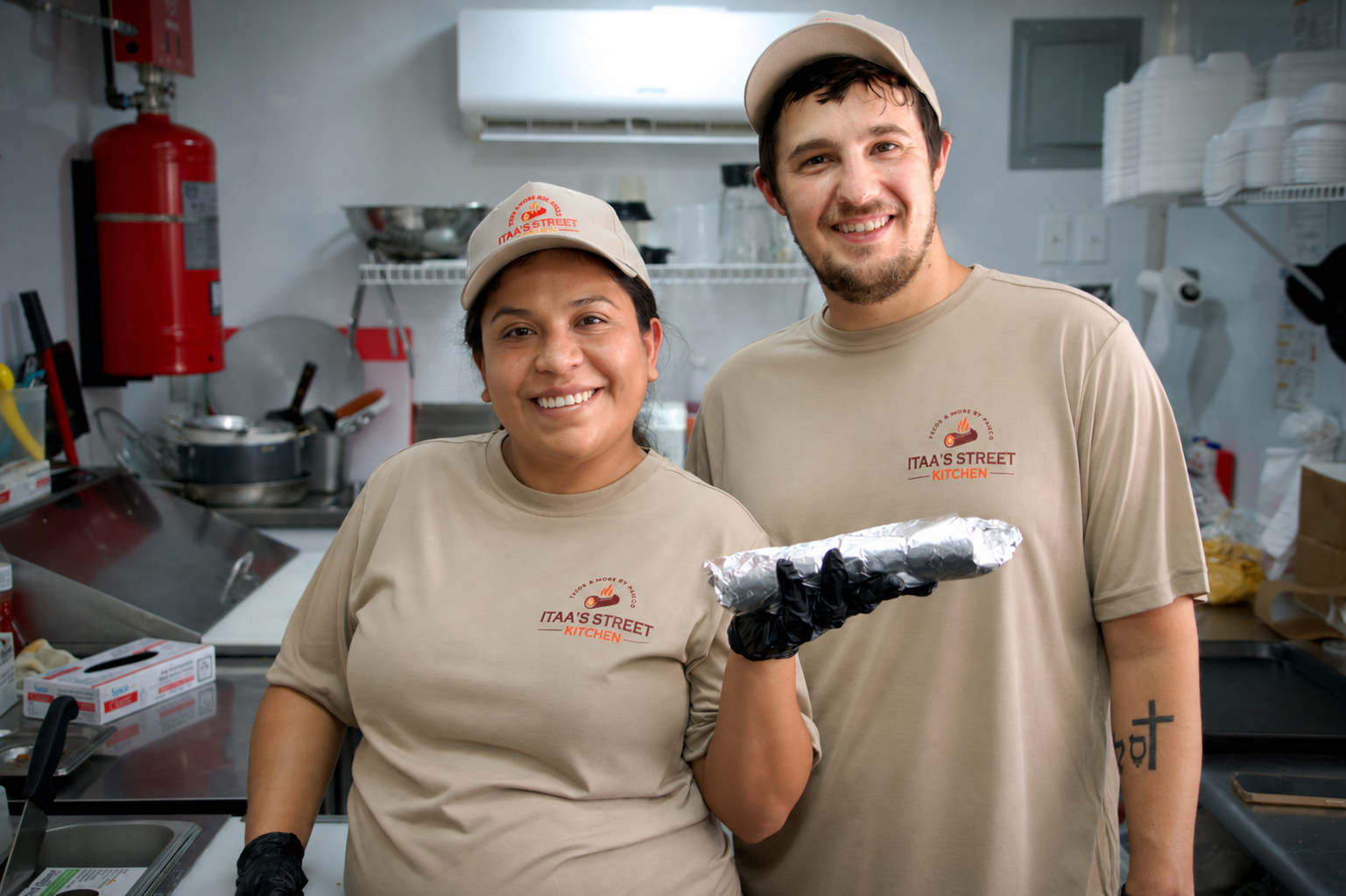 Patricia and Davy smiling inside Itaa’s Street Kitchen food truck